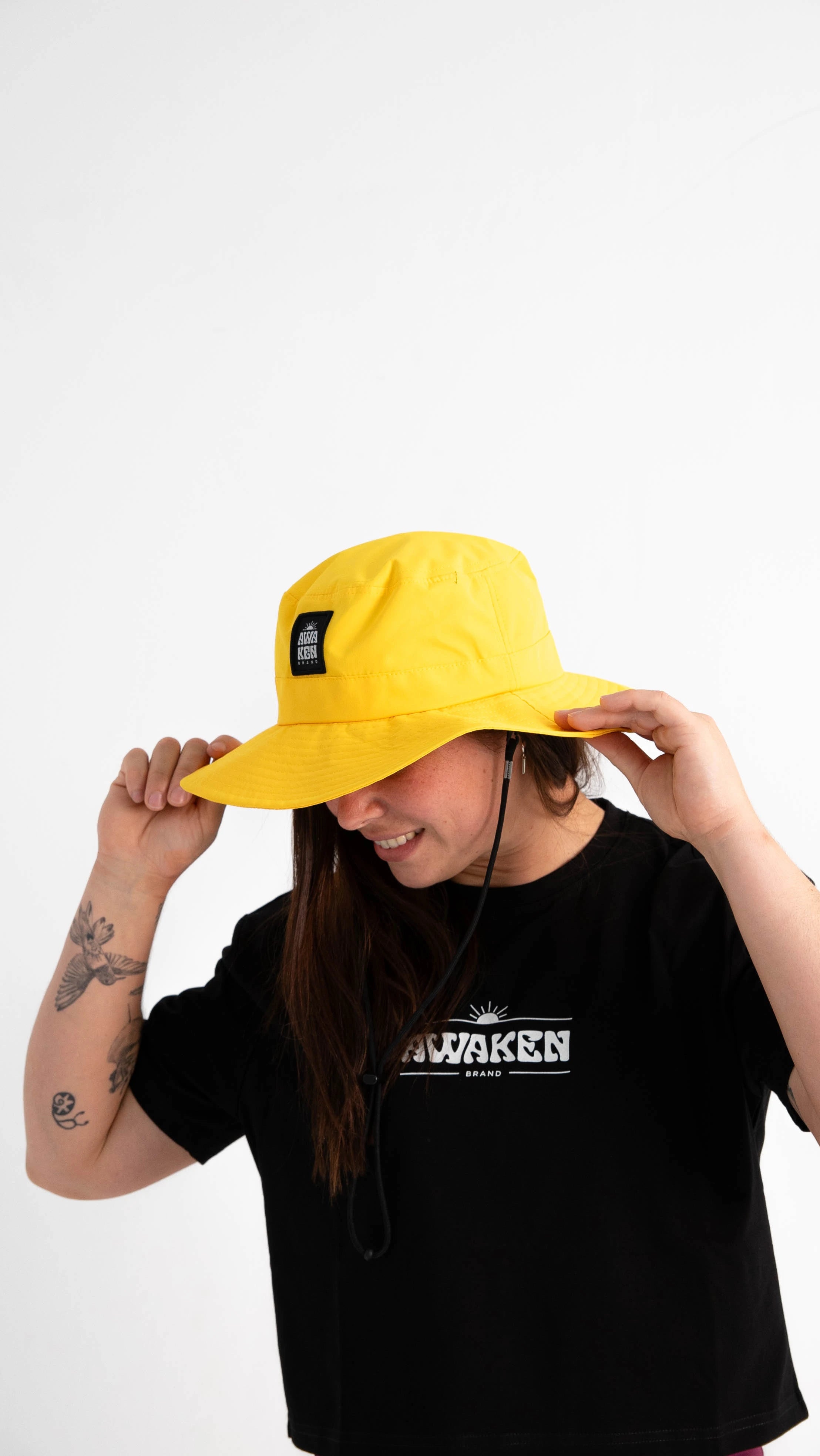 Gorro impermeable con cuerda detalle logo color amarillo amanecer