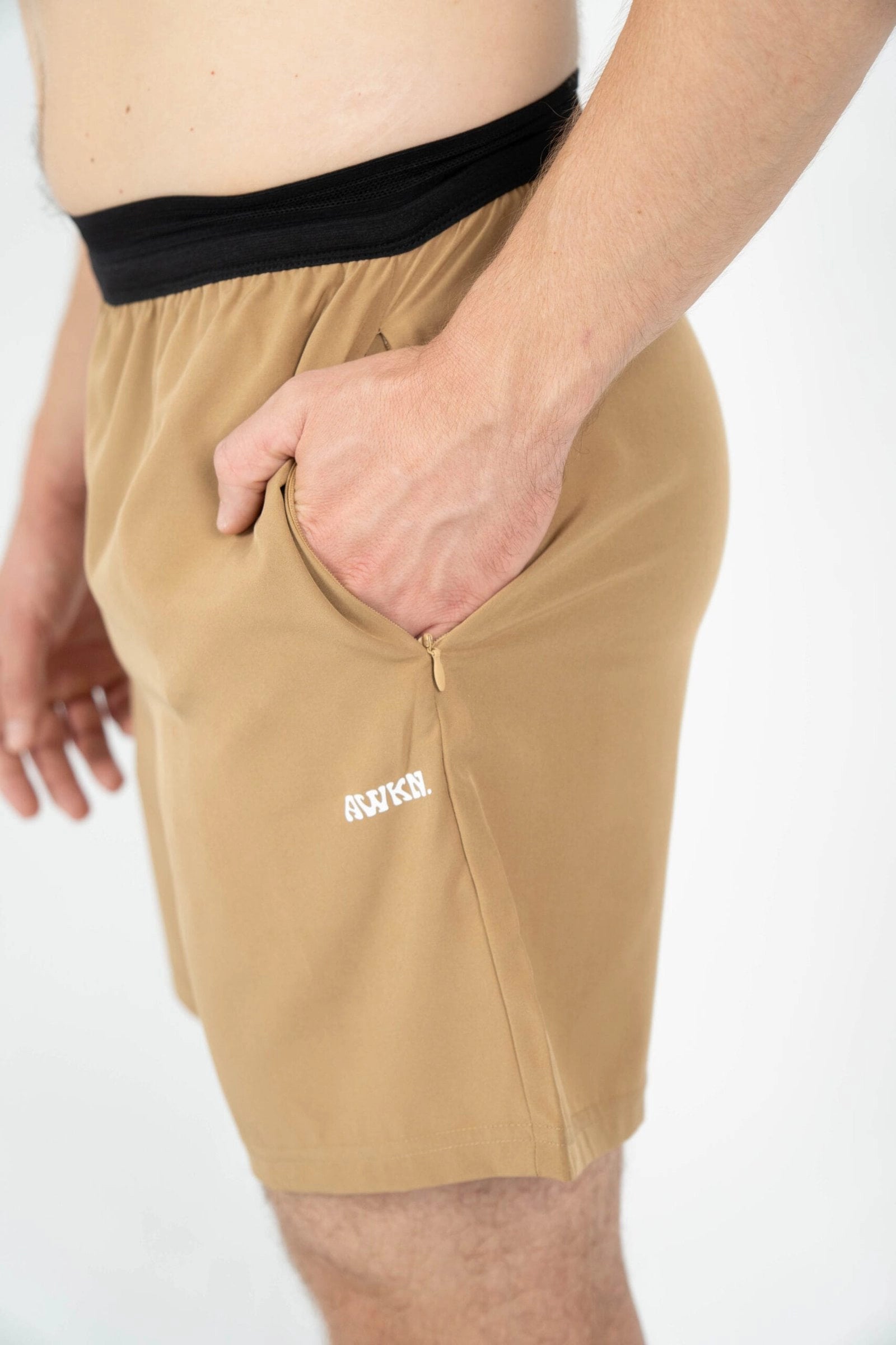 Pantalón corto hombre perfil detalle logo color marrón tierra